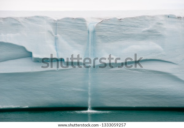 北極圏での地球温暖化により 氷が溶けると氷河の壁の端に海に落ちる滝ができます 気候の危機と崩壊 画像 の写真素材 今すぐ編集
