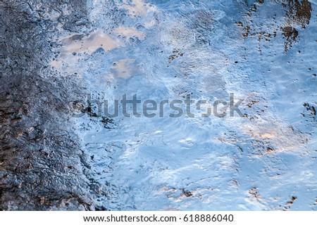 Melting ice texture with reflection of blue sky