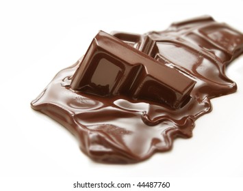 Melting Piece Of Dark Chocolate Bar On White Background