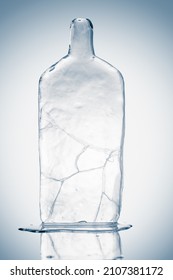 Melting piece of ice in form of a glass bottle. Sculpture, made of clean ice.