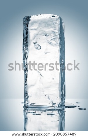 A melting rectangular piece of clean ice, isolated on white background with reflection. Purity concept.
