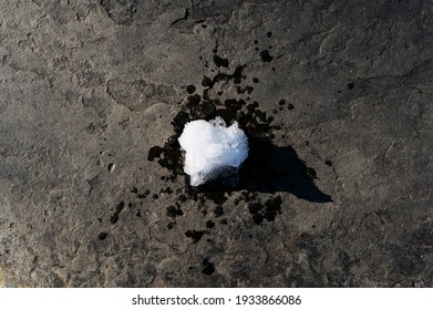 Melting Snowball Thawing On Sidewalk