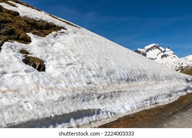 Melting Winter Snow Against A Mountain Side In The Swiss Alps