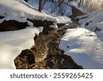 Meltwater runs through a snow-covered ravine in early spring