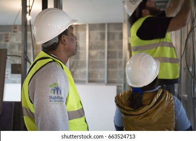 A Member From Habitat For Humanity New York City Works With Volunteers On A Home Building Construction Project In The Brownsville Section Of Brooklyn During Fleet Week New York - NEW YORK MAY 25 2017.