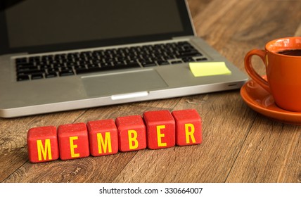 Member Written On A Wooden Cube In Front Of A Laptop