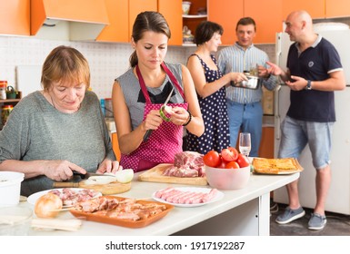 Members Of Big Family Making Dinner Together In Kitchen