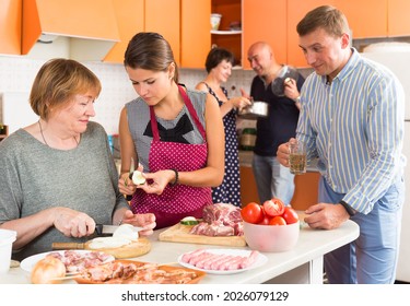 Members Of Big Family Making Dinner Together In Kitchen