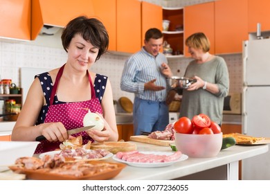 Members Of Big Family Making Dinner Together In Kitchen