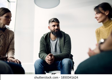 Members Of Group Therapy Having A Meeting At Community Center.. Focus Is On Smiling Man In The Middle. 