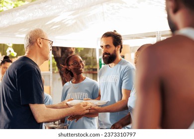 Members of a multicultural community come together, volunteering at non-profit center to donate food and essentials to the homeless and underprivileged. Young volunteers helping the poor and needy. - Powered by Shutterstock