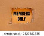 Members only message written on ripped torn cardboard paper with orange background. Conceptual members only symbol. Copy space.