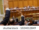 Members of Romanian Parliament vote by raising their hands