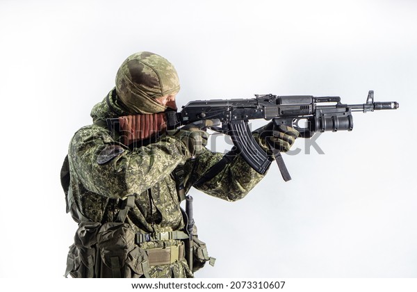 Members of the special purpose unit. A Russian\
special forces soldier with an AK-74 assault rifle aiming from a\
machine gun on a white\
background