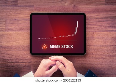 Meme stock investment warning concept with digital tablet. Soaring graph of stock or cryptocurrency and notification about meme stock hazardous investment, risk and threat.