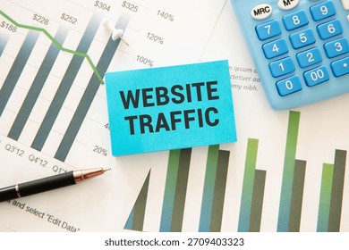 Memo note written with text WEBSITE TRAFFIC isolated on green background.
