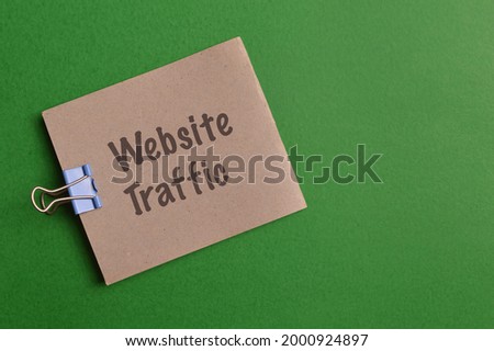 Memo note written with text WEBSITE TRAFFIC isolated on green background