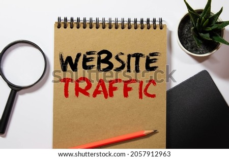 Memo note written with text WEBSITE TRAFFIC isolated on green background