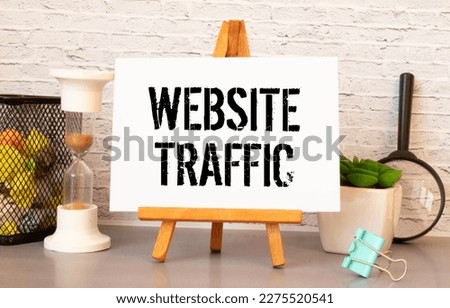 Memo note written with text WEBSITE TRAFFIC isolated on green background