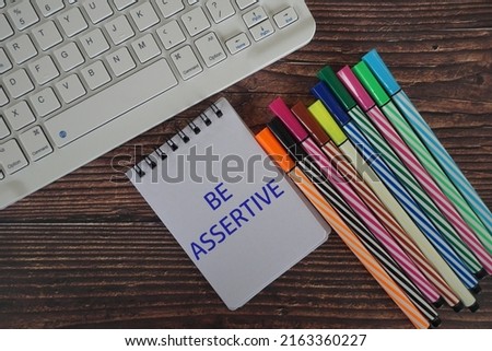 memo pad with text Be Assertive
