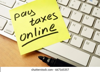 Memo stick with words pay taxes online. - Shutterstock ID 667165357
