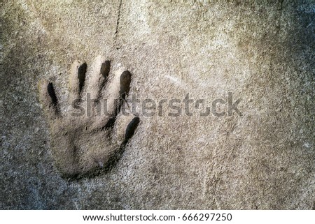 Memorable handprint of a hand in an old concrete wall