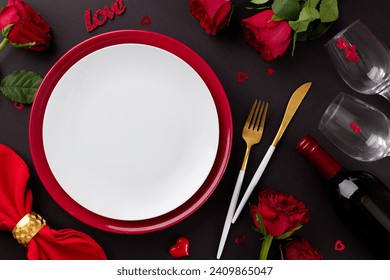 Memorable Valentine's Day dining event. Top view photo of plates, cutlery, hearts, red roses, wineglasses, presents, red napkin, wine bottle, candle on black background with advert zone - Powered by Shutterstock