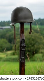 Memorial Battlefield Cross. The Symbol Of A Fallen US Soldier. M1 Rifle With Helmet.