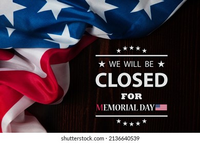 Memorial Day Background Design. American flag on a background of wooden teable with a message. We will be Closed for Memorial Day.