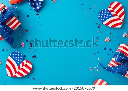 Memorial Day celebration vibes. Top view of patriotic embellishments—adorable hearts featuring USA flag, confetti, gift boxes wrapped in thematic paper—set against blue backdrop with space for text