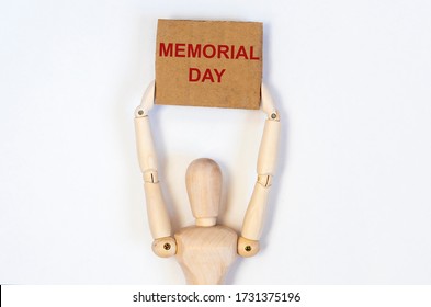 Memorial Day holiday sign text on poster craft paper in hands of wooden man isolated on a white background - Shutterstock ID 1731375196
