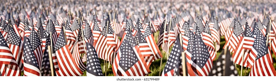 Memorial Day tribute. Thousands of tiny flags in a field. Faded vintage color. Banner format