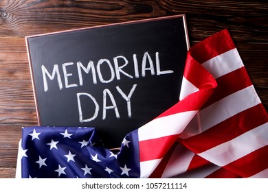 Memorial day weekend text written on wooden black chalkboard with USA flag. United States of America stars & stripes patriot veteran remembrance symbol. Background, close up, copy space, top view. - Shutterstock ID 1057211114