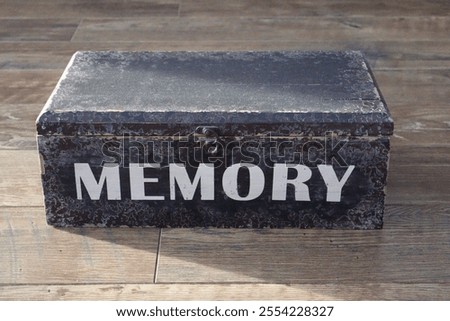 A memory box on the floor. Looking vintage and worn. Containing memories of celebrations, special occasions and events.