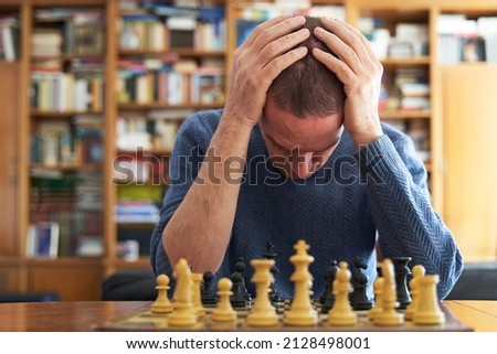 Memory loss and Alzheimer problem. Senior man devastated over chess board