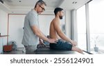 Men, back pain and injury with massage with physiotherapy at clinic with recovery, process and relief. People, patient and biokinetics for ache, spine and rehabilitation for wellness at hospital