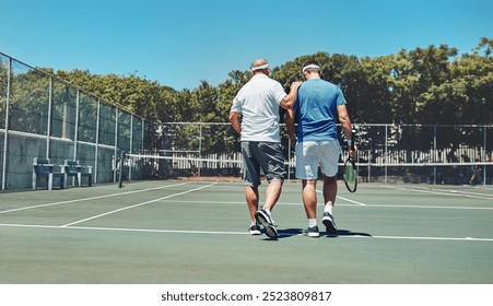 Men, back and walking with practice at tennis court for exercise, discussion and support in fitness. Friends, conversation and male athlete with racket at sports club for match, training and workout - Powered by Shutterstock