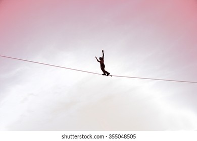 Men balancing on slackline with sky view 