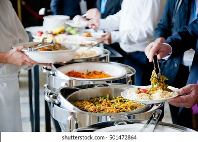 Men In Blue Suits Choosing Food At A Banquet