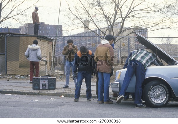 Men\
with boom box repairing car, South Bronx, New\
York