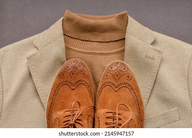 Men brown suede brogue shoes combined with light beige blazer and sweater. Top view.
