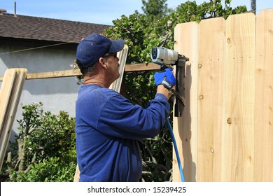 Men Building A Fence In Garden