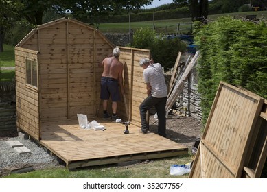 MEN BUILDING A WOODEN GARDEN SHED - CIRCA  2013 - Erecting A New Garden Shed In A Country Garden