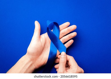 Men cancer. Blue ribbon in hands isolated on deep blue background. Awareness prostate cancer of men health in November. Adrenocortical carcinoma concept - Powered by Shutterstock