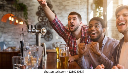 Men Cheering For Football Team And Drinking Beer In Sport Bar