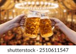 Men clinking mugs with beer during celebration of Oktoberfest outdoors, background.Cheers with beer and enjoy tradition.