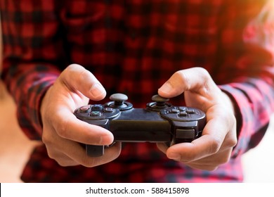 Men control games.A young man holding game controller playing video games
				