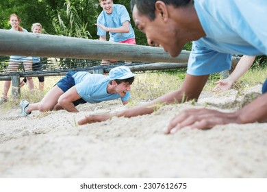 Men crawling under net on boot camp obstacle course - Powered by Shutterstock