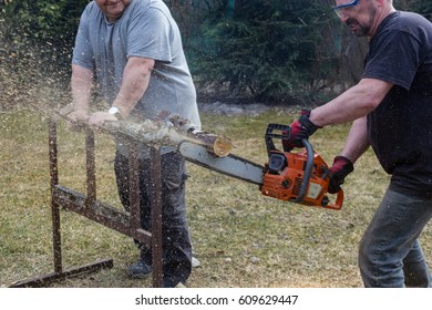 Men Cutting Wood With A Chainsaw, Flying Wood Chips