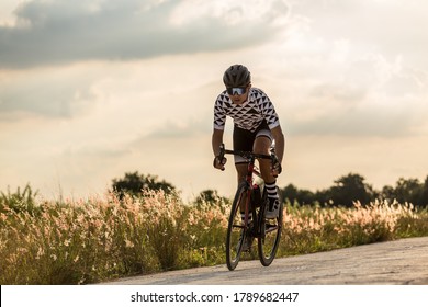 Men cycling mountain road bike at sunset.